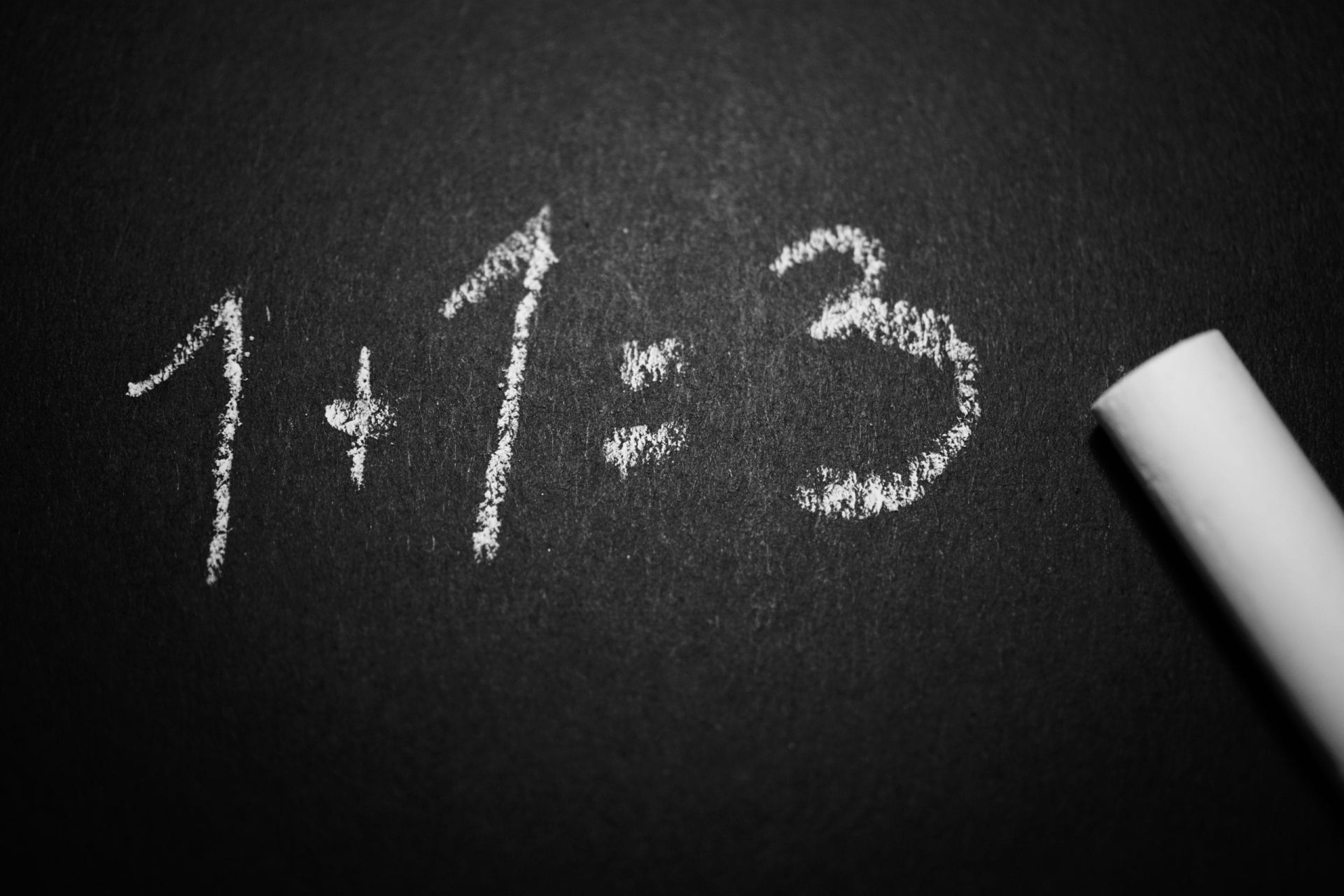 chalk drawing on a blackboard of 1 + 1 = 3